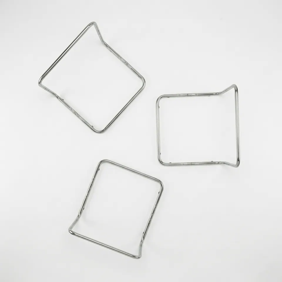 Overhead flat lay of three chrome tubular L-shaped frames on white, showing each square base and upright back from above