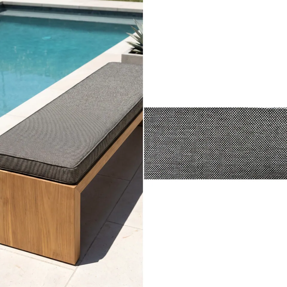 Charcoal salt-and-pepper box cushion with self piping on a pale oak slab bench beside a turquoise pool, fabric strip