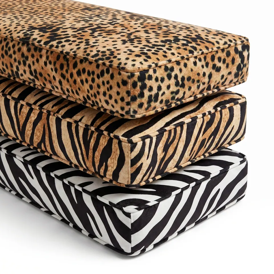 Three velvety box cushions stacked on white: cheetah spot on top, tiger stripe in the middle and zebra stripe below