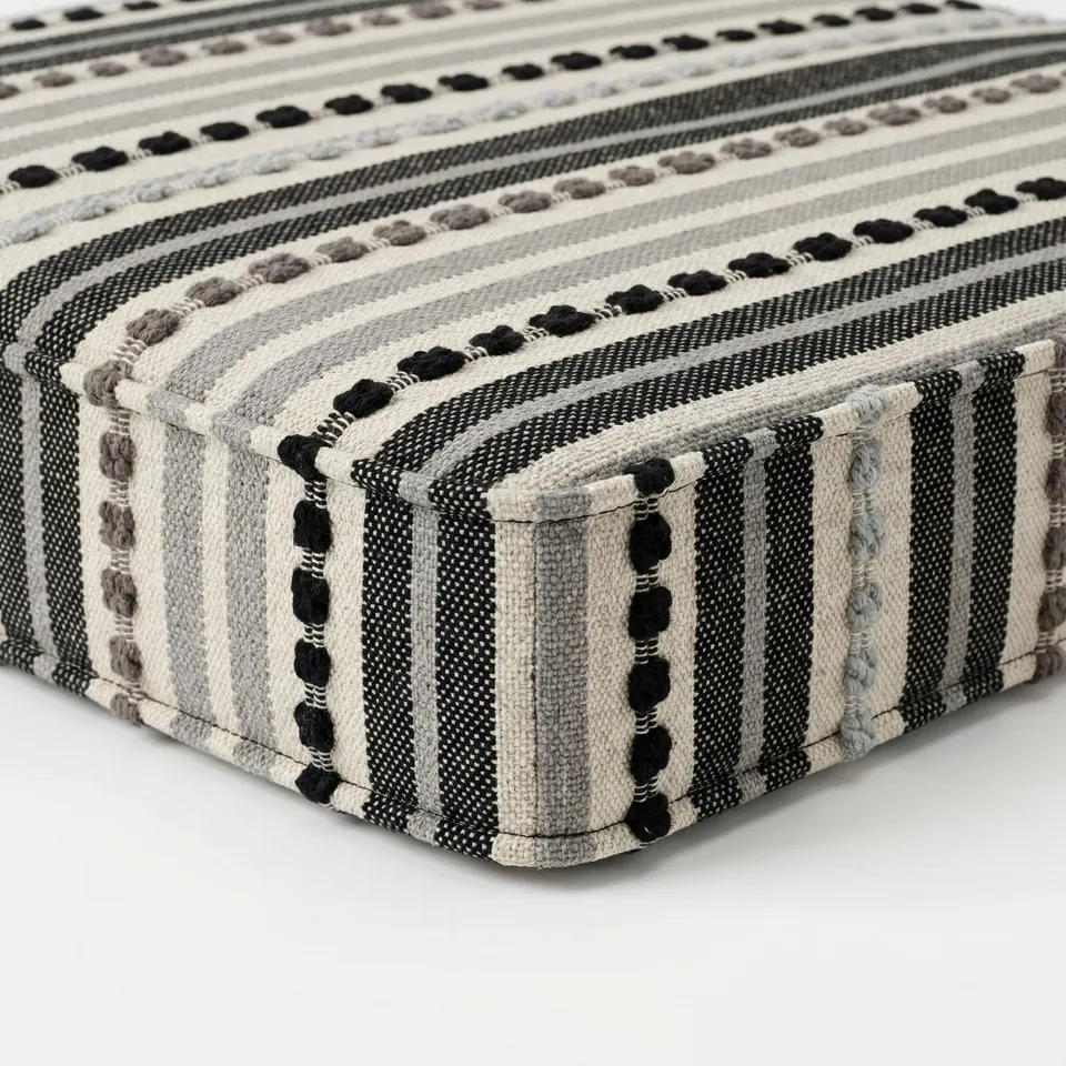Black, gray and cream knotted stripe box cushion with a square self-piped corner on a bright white studio surface