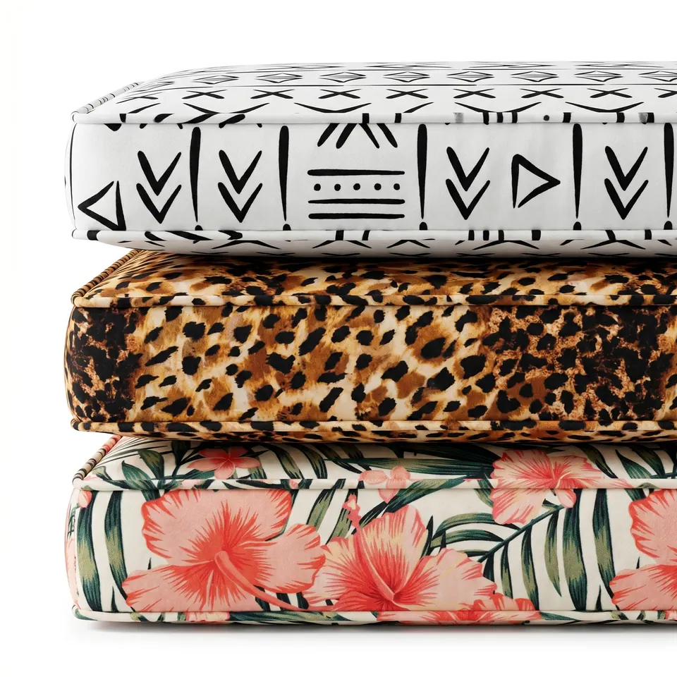 Side view of three box cushions stacked: white mudcloth, leopard spot and coral hibiscus prints with matching piping