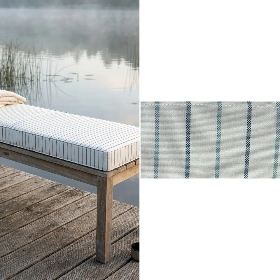Ivory bench cushion with navy and teal pinstripes on a weathered teak bench on a wooden jetty over a misty lake, fabric strip