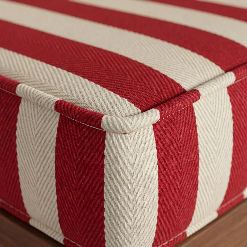 Macro of a red and cream herringbone twill stripe cushion corner with matching self piping