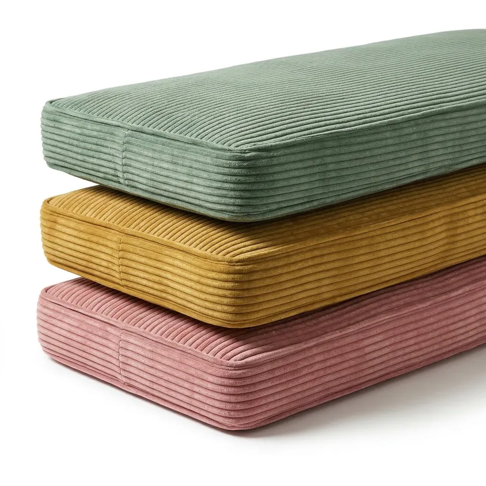 Close view of sage, mustard and pink corduroy bench cushions stacked to show ribbed borders and self piping