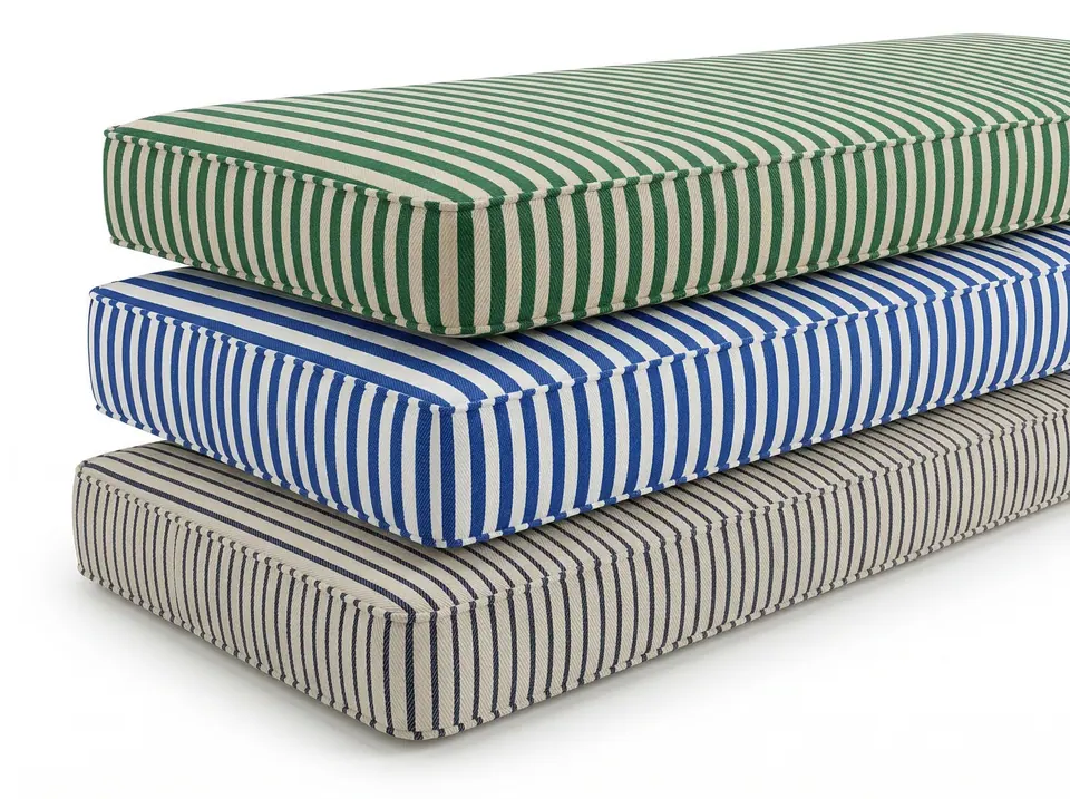 Three striped box cushions stacked on white: green and ecru, cobalt and white, and a navy pinstripe on greige