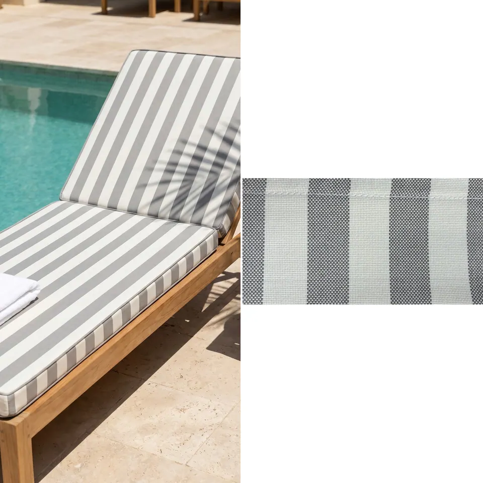 Gray and white wide stripe sunbed cushion with raised back on a teak lounger beside a pool, folded white towel, fabric strip