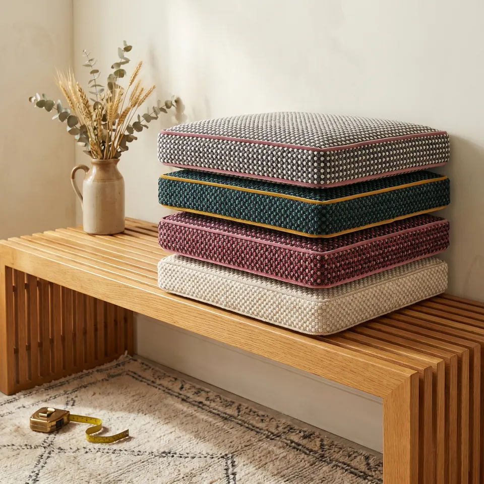 Pinned: Stack of four square dotted chenille box cushions in charcoal, teal, plum and cream with pink and mustard velvet piping