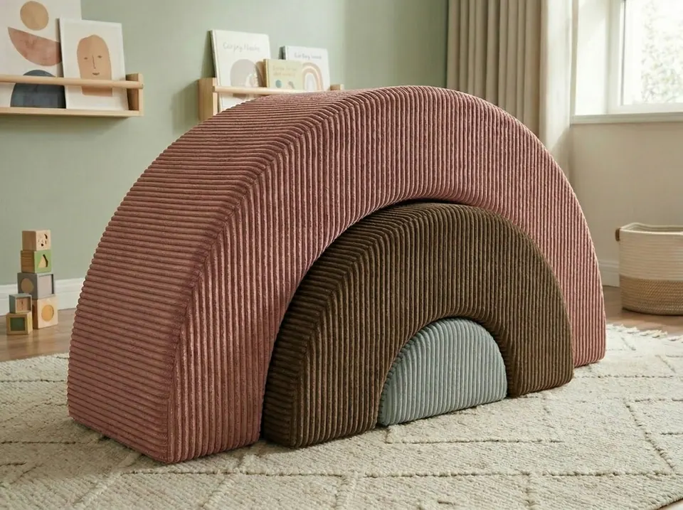Dusty rose corduroy rainbow arch nesting an olive arch and a powder blue dome on a cream rug in a sage playroom