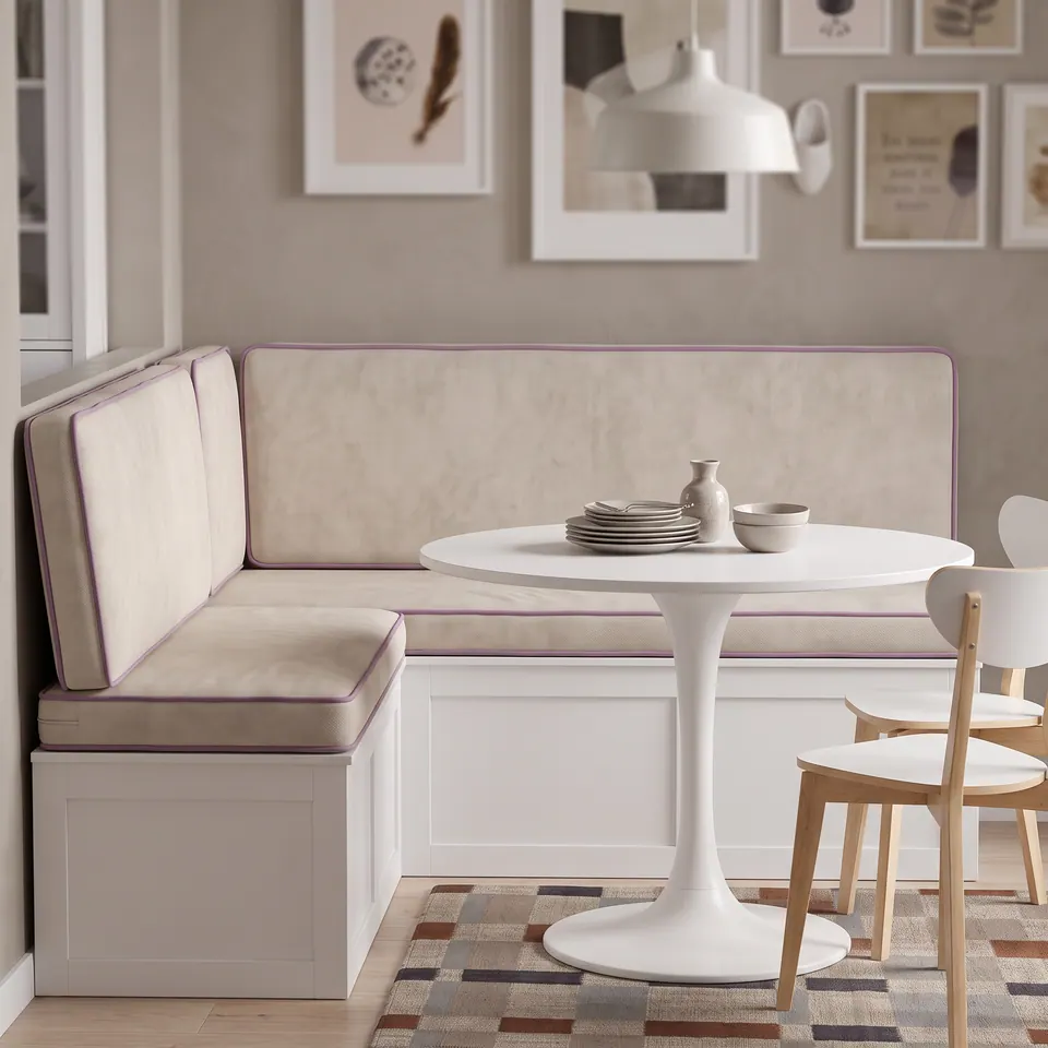 Oat velvet corner banquette cushions with lavender piping on a white bench facing a white tulip table and bentwood chairs