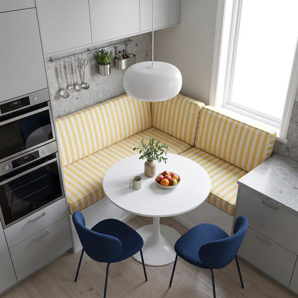 Pinned: Overhead view of yellow and white striped L-shaped nook cushions around a white tulip table with two navy chairs