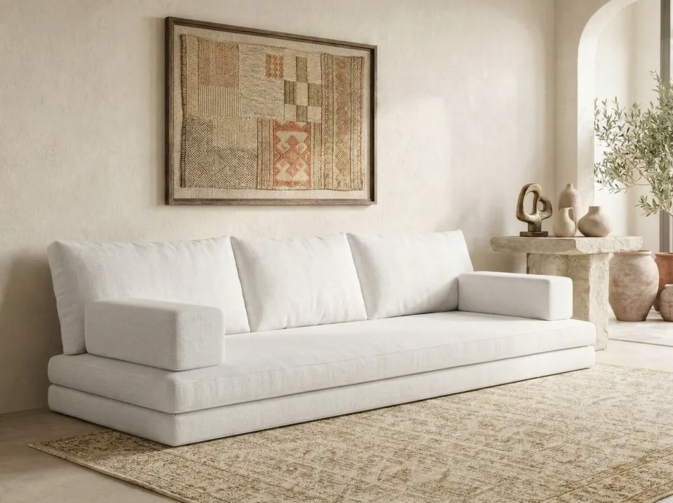 Ivory linen-look floor sofa with stacked base cushions, back cushions and arm blocks in a limewashed Mediterranean room