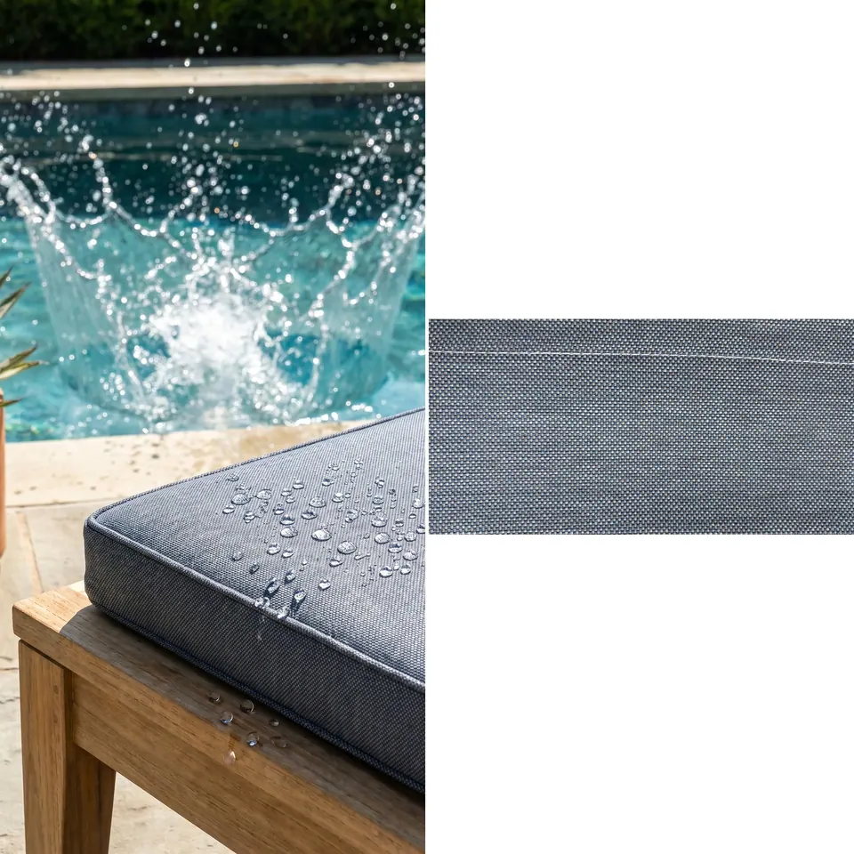 Water droplets beading on a slate blue piped outdoor box cushion on a teak frame, with a splash in the pool behind