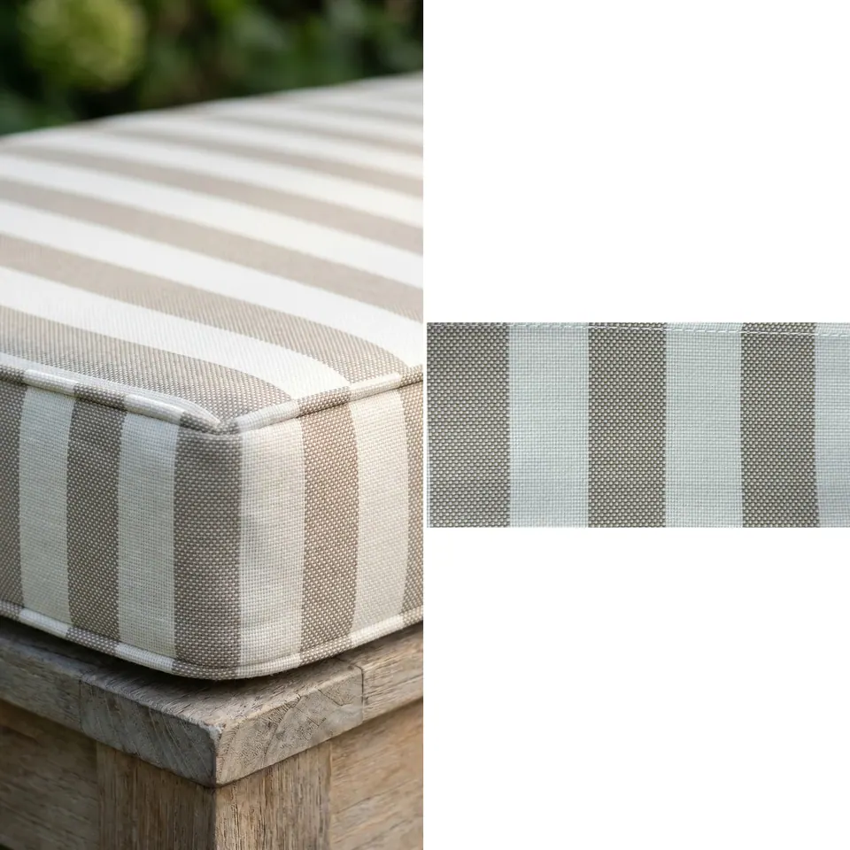 Close view of a taupe and ivory wide stripe box cushion corner with self piping on a weathered wooden bench, fabric strip