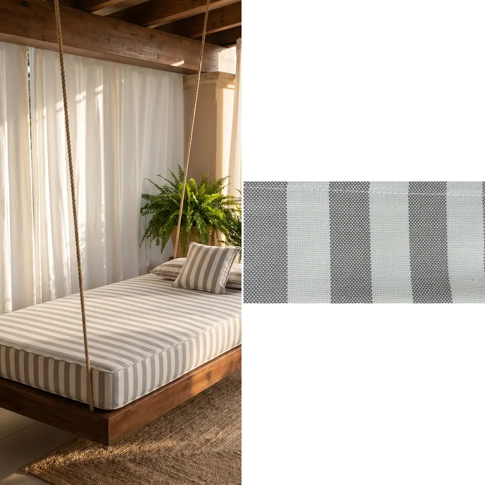 Taupe and white wide stripe mattress cushion with matching pillows on a rope-hung wooden swing bed, sheer curtains behind