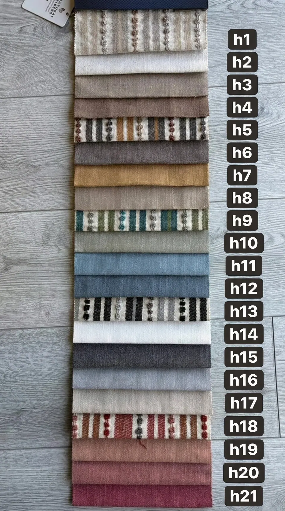 Cotton sample card of 21 numbered strips: plain neutrals, mustard, blues, reds and five knotted woven stripes