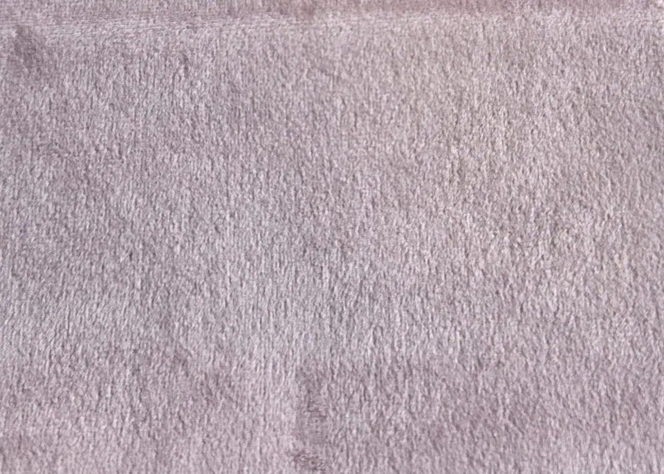 Dusty rose velvet fabric sample with a lilac cast, fine pile and a faint storage crease near the bottom edge