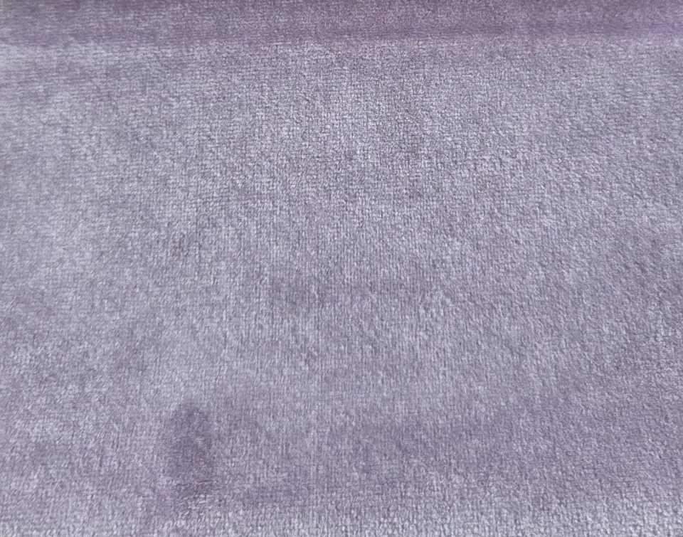 Lilac lavender-gray velvet swatch with short pile, a richer violet fold at the top and a pressed mark lower left